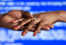 hand intertwined, one has engagement ring