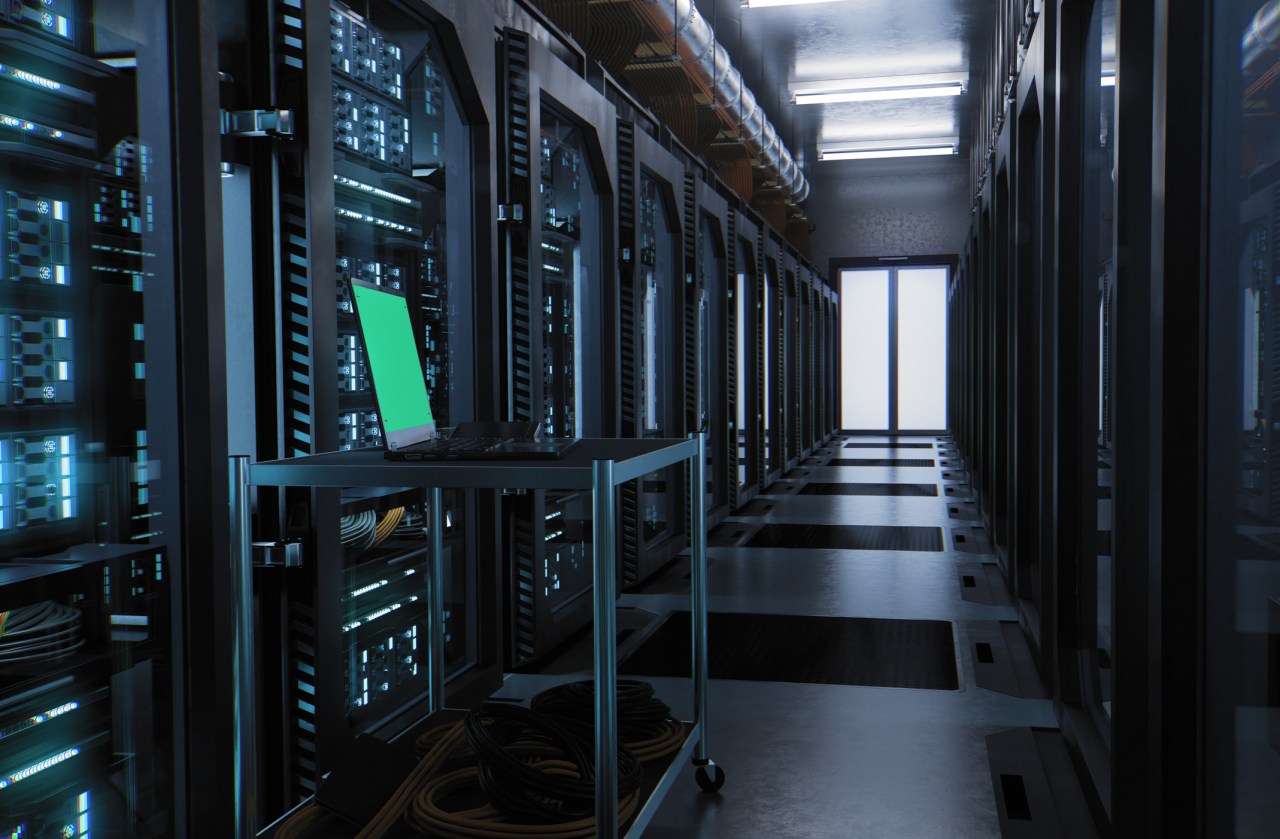 Server room with laptop sitting on a table inside data center.