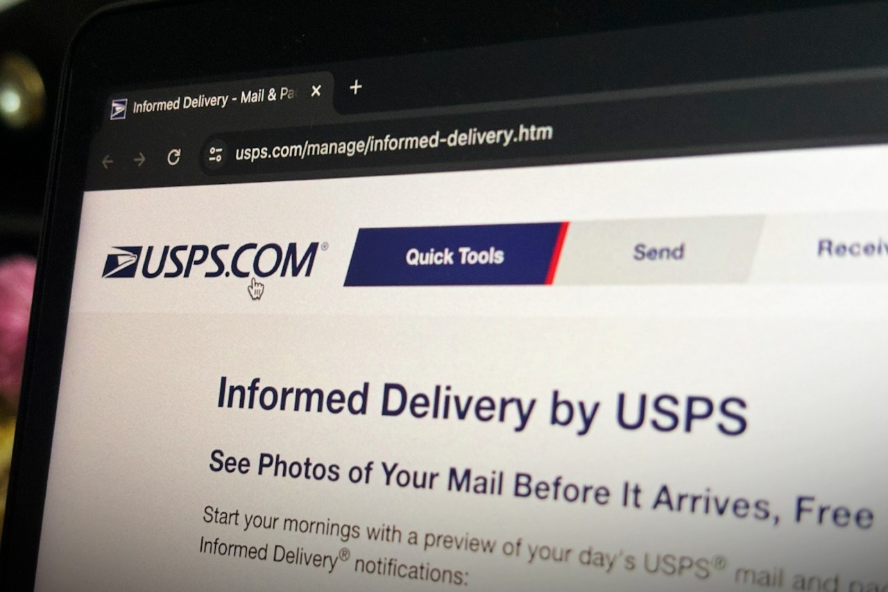 a photo of USPS' website home page on a computer display in the dark